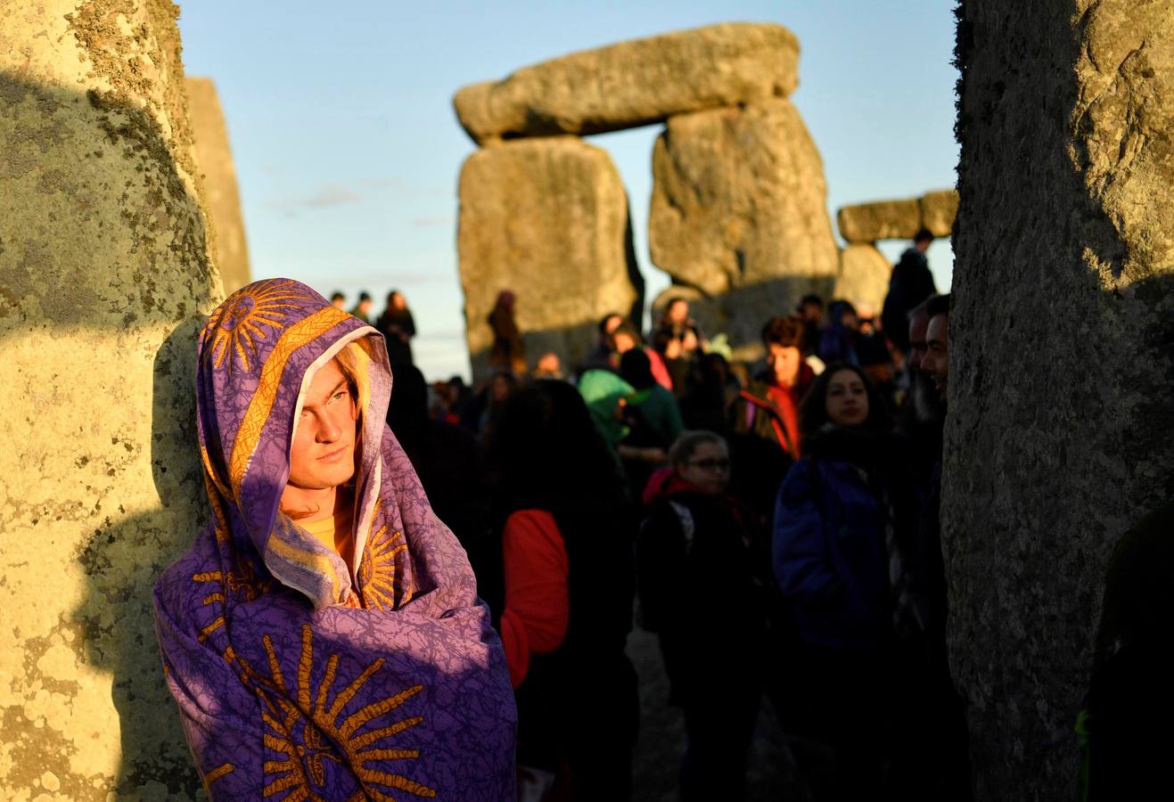 Varios entusiastas reciben el amanecer mientras participan en las celebraciones por el solsticio de verano en Stonehenge, en Wiltshire (Reino Unido). Este festival atrae anualmente a cientos de personas para celebrar el llegada del día más largo en el hemisferio norte.