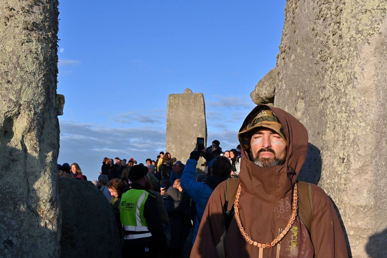 Varios entusiastas reciben el amanecer mientras participan en las celebraciones por el solsticio de verano en Stonehenge, en Wiltshire (Reino Unido). Este festival atrae anualmente a cientos de personas para celebrar el llegada del día más largo en el hemisferio norte.