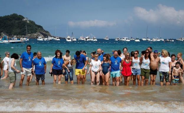 El alcalde donostiarra, Eneko Goia (3i), se ha bañado junto a decenas de personas este domingo en la playa de La Concha de San Sebastián. 