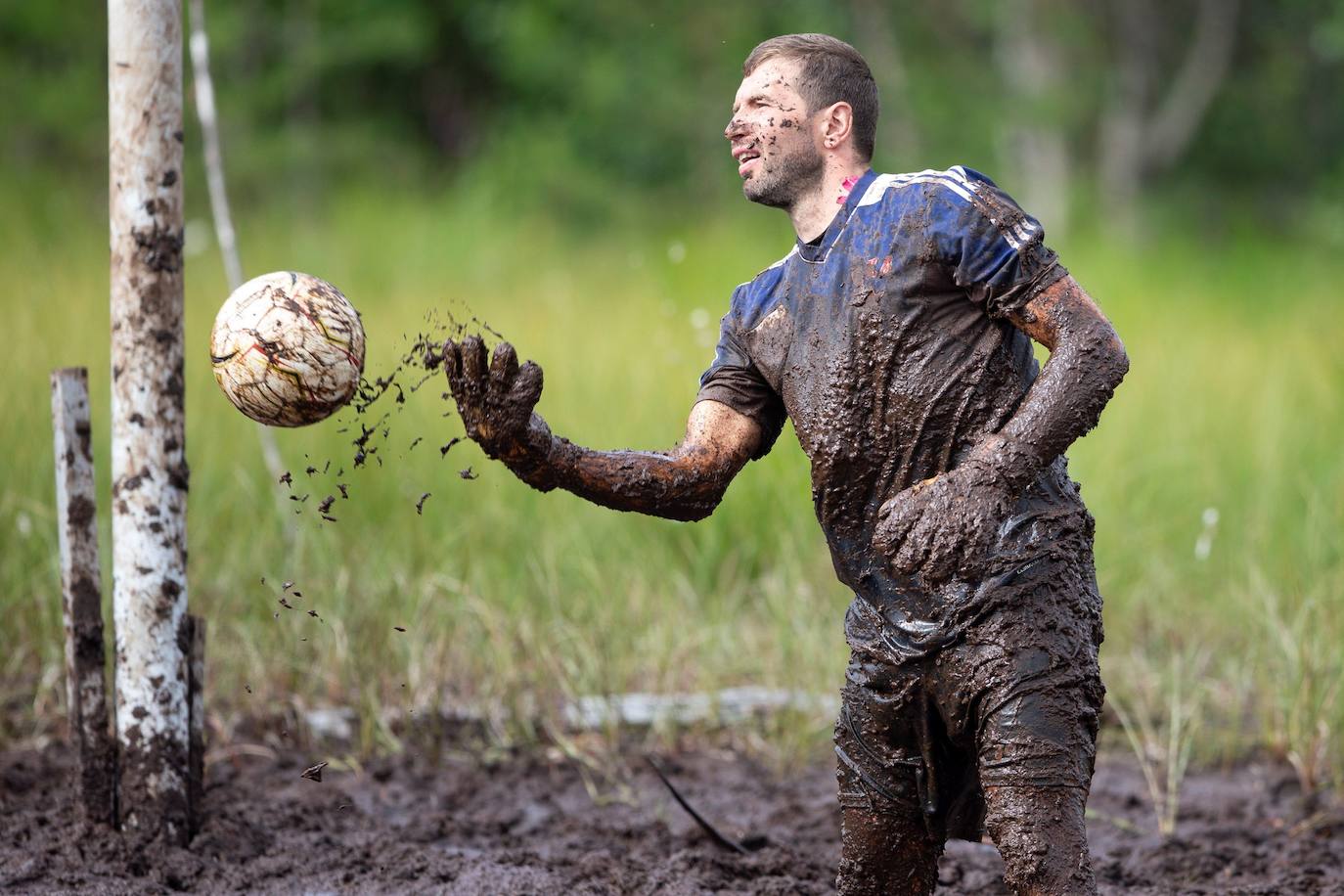 Varios participantes pugnan por la posesión de un balón durante los campeonatos de fútbol sobre barro disputados en Hyrynsalmi (Finlandia).