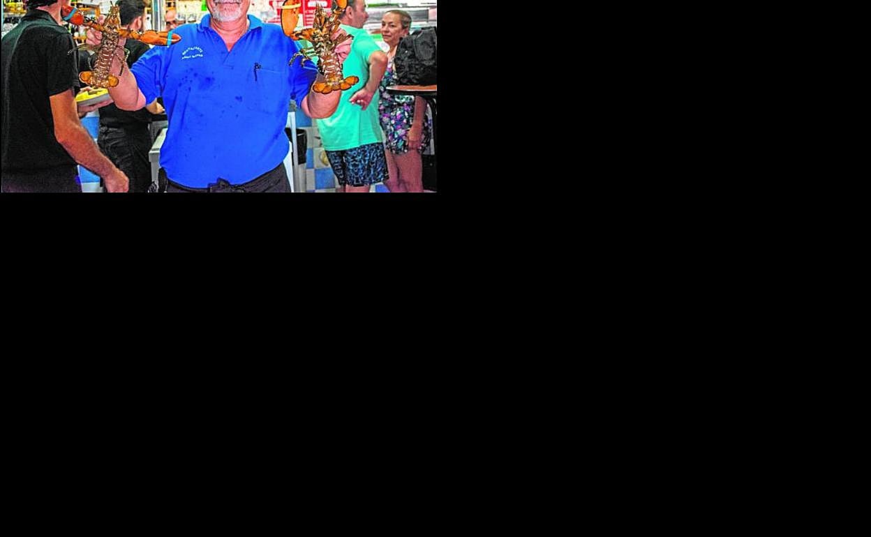 Pedro Rosique, exmarino y exactor, encargado del restaurante Mares Bravas en Cala Cortina, enseña dos bogavantes. 