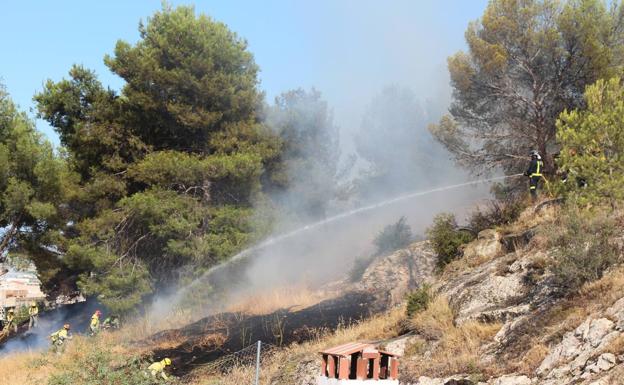 Los bomberos trabajan en la extinción del fuego, en la ladera del Castillo de Yecla. 