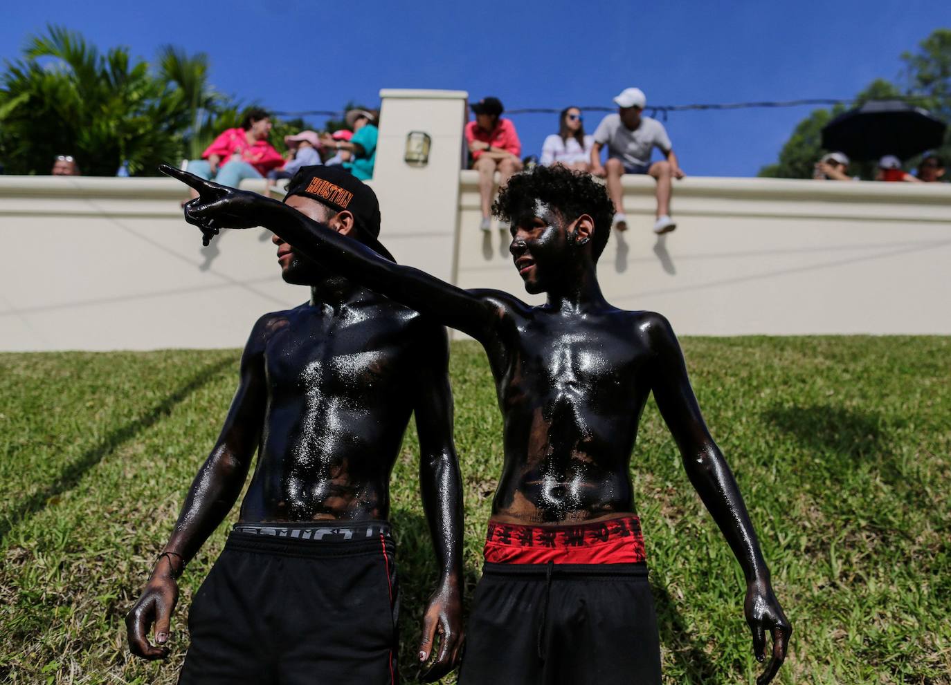 Varias personas llevan el cuerpo cubierto con aceite para cumplir con la tradición de «Los Diablitos Negros» durante una procesión en la que fieles católicos transportan la imagen de Santo Domingo de Guzmán, en Managua (Nicaragua). Como es tradición, la música pone el tono festivo y los creyentes bailan a la vez que avanzan hacia el norte de Managua, alrededor de la imagen, que es zangoloteada por los cargadores, como símbolo de alegría.