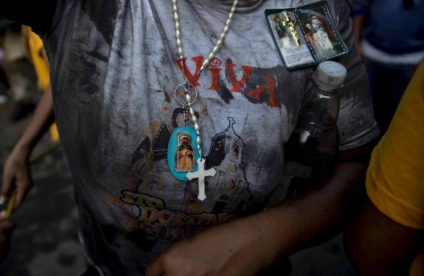 Varias personas llevan el cuerpo cubierto con aceite para cumplir con la tradición de «Los Diablitos Negros» durante una procesión en la que fieles católicos transportan la imagen de Santo Domingo de Guzmán, en Managua (Nicaragua). Como es tradición, la música pone el tono festivo y los creyentes bailan a la vez que avanzan hacia el norte de Managua, alrededor de la imagen, que es zangoloteada por los cargadores, como símbolo de alegría.