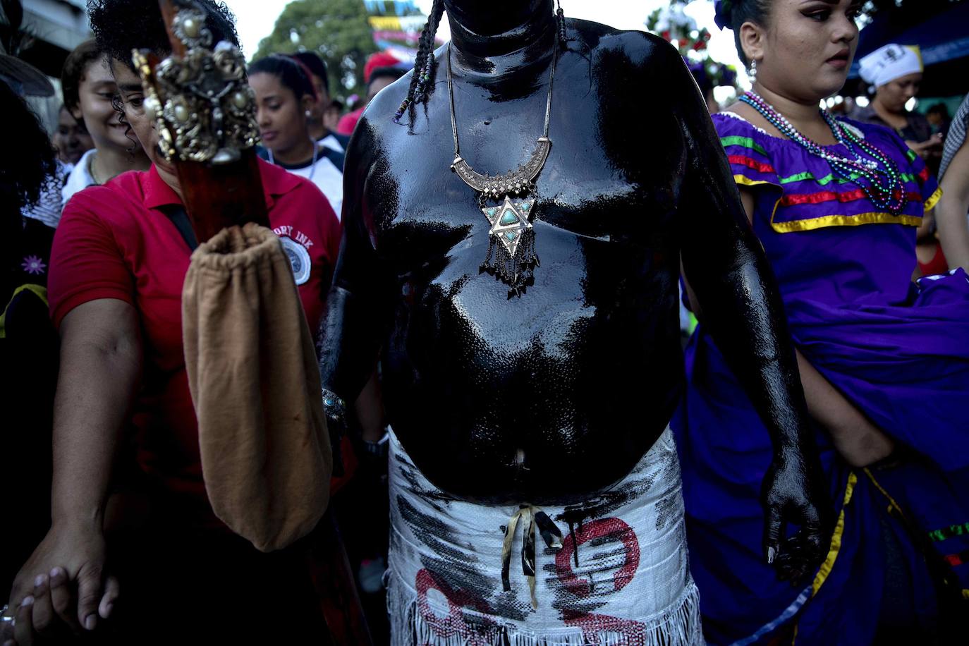 Varias personas llevan el cuerpo cubierto con aceite para cumplir con la tradición de «Los Diablitos Negros» durante una procesión en la que fieles católicos transportan la imagen de Santo Domingo de Guzmán, en Managua (Nicaragua). Como es tradición, la música pone el tono festivo y los creyentes bailan a la vez que avanzan hacia el norte de Managua, alrededor de la imagen, que es zangoloteada por los cargadores, como símbolo de alegría.
