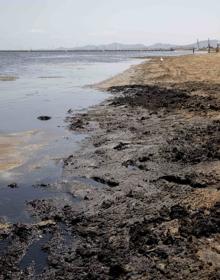 Imagen secundaria 2 - 1. Unos bañistas entran en el agua, tras cruzar una pasarela improvisada con tablones para evitar la zona de lodos, anteayer en la playa de Los Urrutias. | 2. Un árbol caído en la calle Antonio Reverte de Los Urrutias. | 3. Fango, en la zona de apartamentos Vistamar, en Los Urrutias.