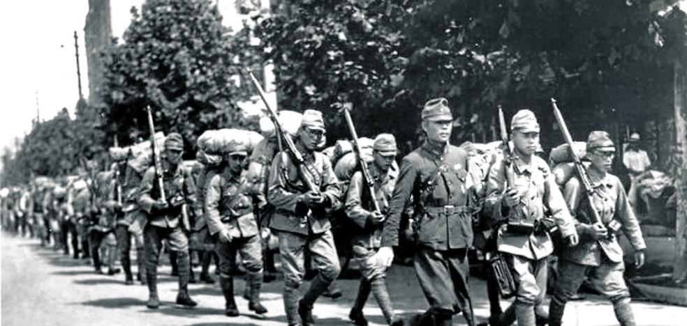 Las tropas japonesas desfilan en Seúl. La represión fue brutal. Debajo, un soldado nipón pasa revista a varias mujeres secuestradas para ser esclavas sexuales. 