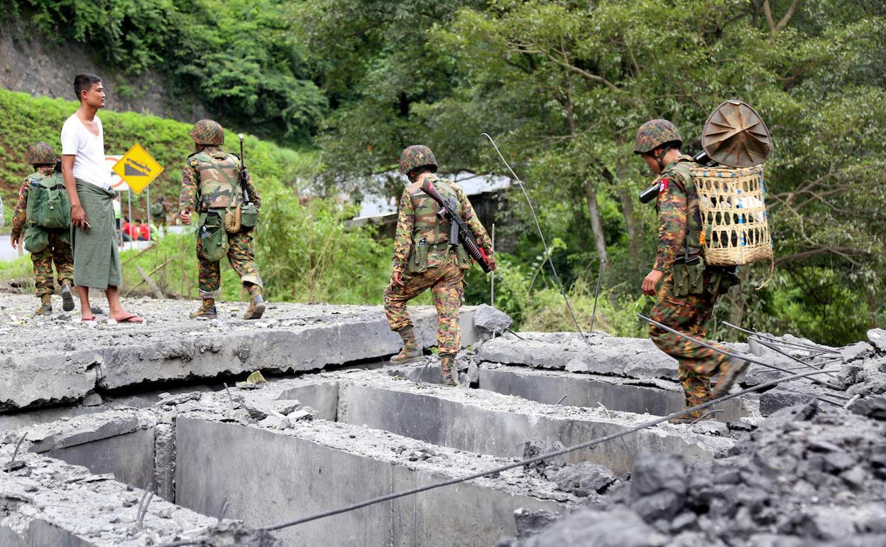 Varios militares y civiles junto al puente volado por los guerrilleros, este jueves.