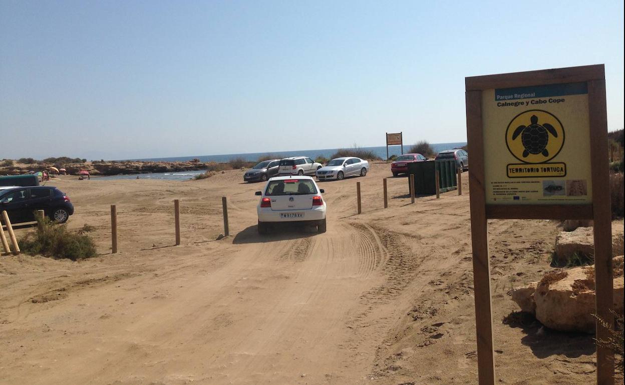 Playa del Charco, el pasado fin de semana, con varios coches aparcados sobre la arena y un vehículo atravesando el hueco dejado por la ausencia de dos bolardos.