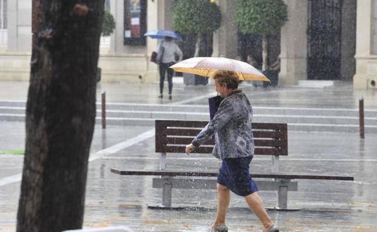 Una mujer camina bajo la lluvia en Murcia.