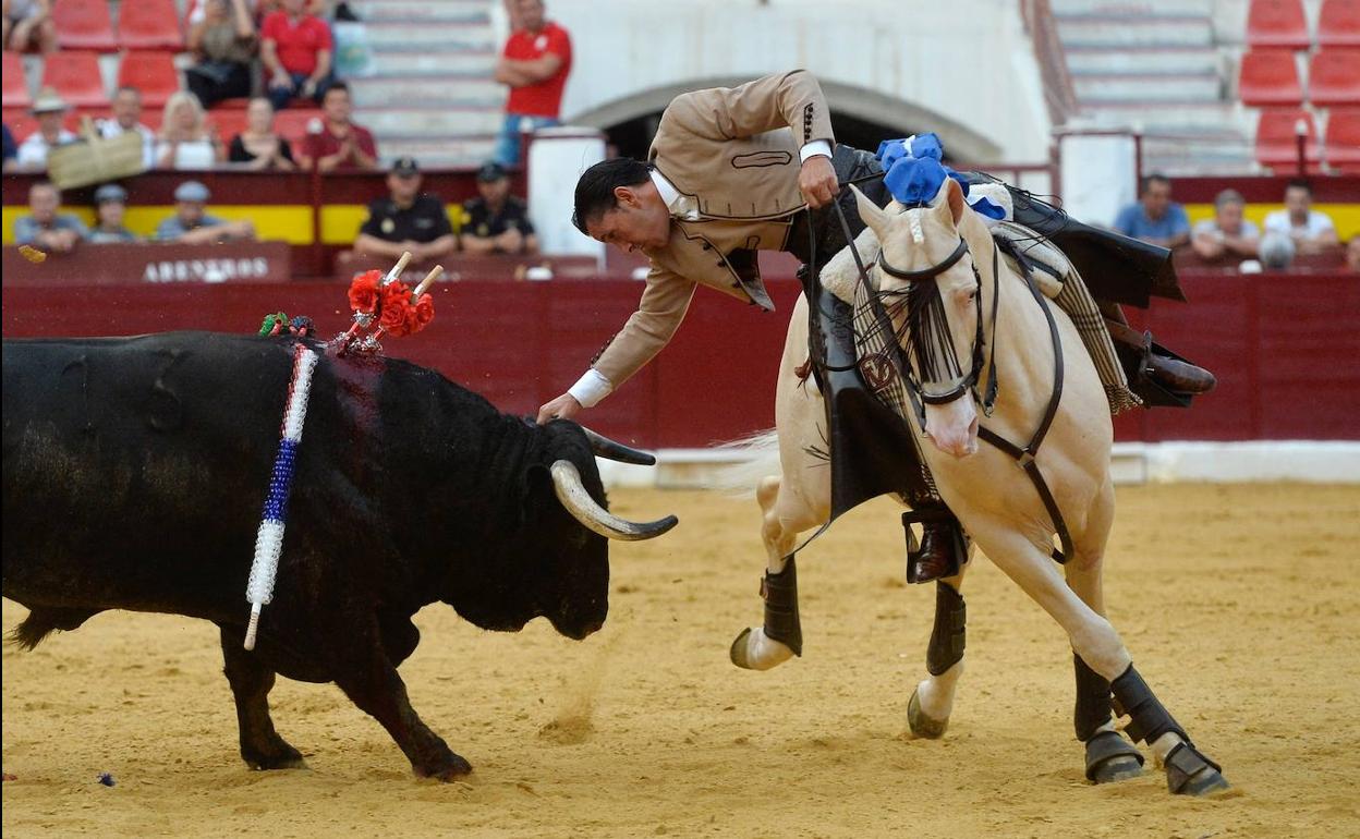 Diego Ventura, triunfador de la tarde, pone la mano sobre la cabeza del astado desde su caballo. 