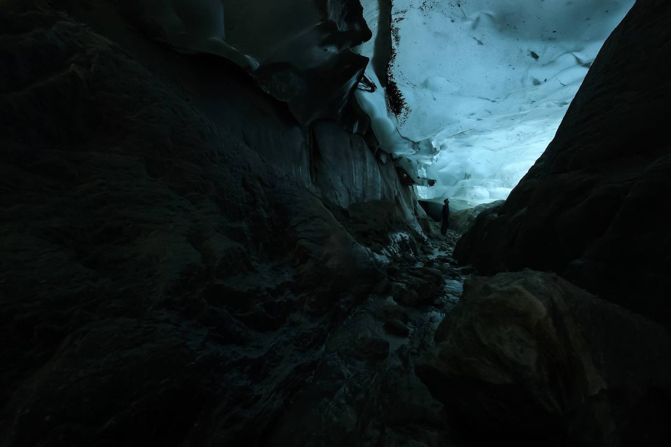 Un hombre mira el glaciar Aletsch desde una cavidad interior, en el Cantón de Valais (Suiza). El glaciar suizo Aletsch es uno más grandes de Europa y el primer lugar de los Alpes declarado Patrimonio de la Humanidad por la Unesco. Este enorme río de hielo se extiende a lo largo de 23 km desde su formación en la región de Jungfrau hasta el desfiladero de Massa, en el Cantón del Valais.