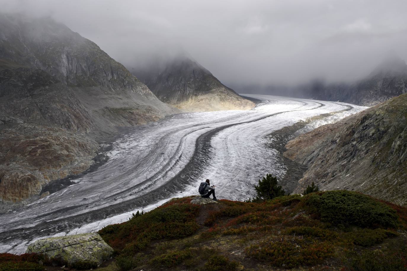 Un hombre mira el glaciar Aletsch desde una cavidad interior, en el Cantón de Valais (Suiza). El glaciar suizo Aletsch es uno más grandes de Europa y el primer lugar de los Alpes declarado Patrimonio de la Humanidad por la Unesco. Este enorme río de hielo se extiende a lo largo de 23 km desde su formación en la región de Jungfrau hasta el desfiladero de Massa, en el Cantón del Valais.