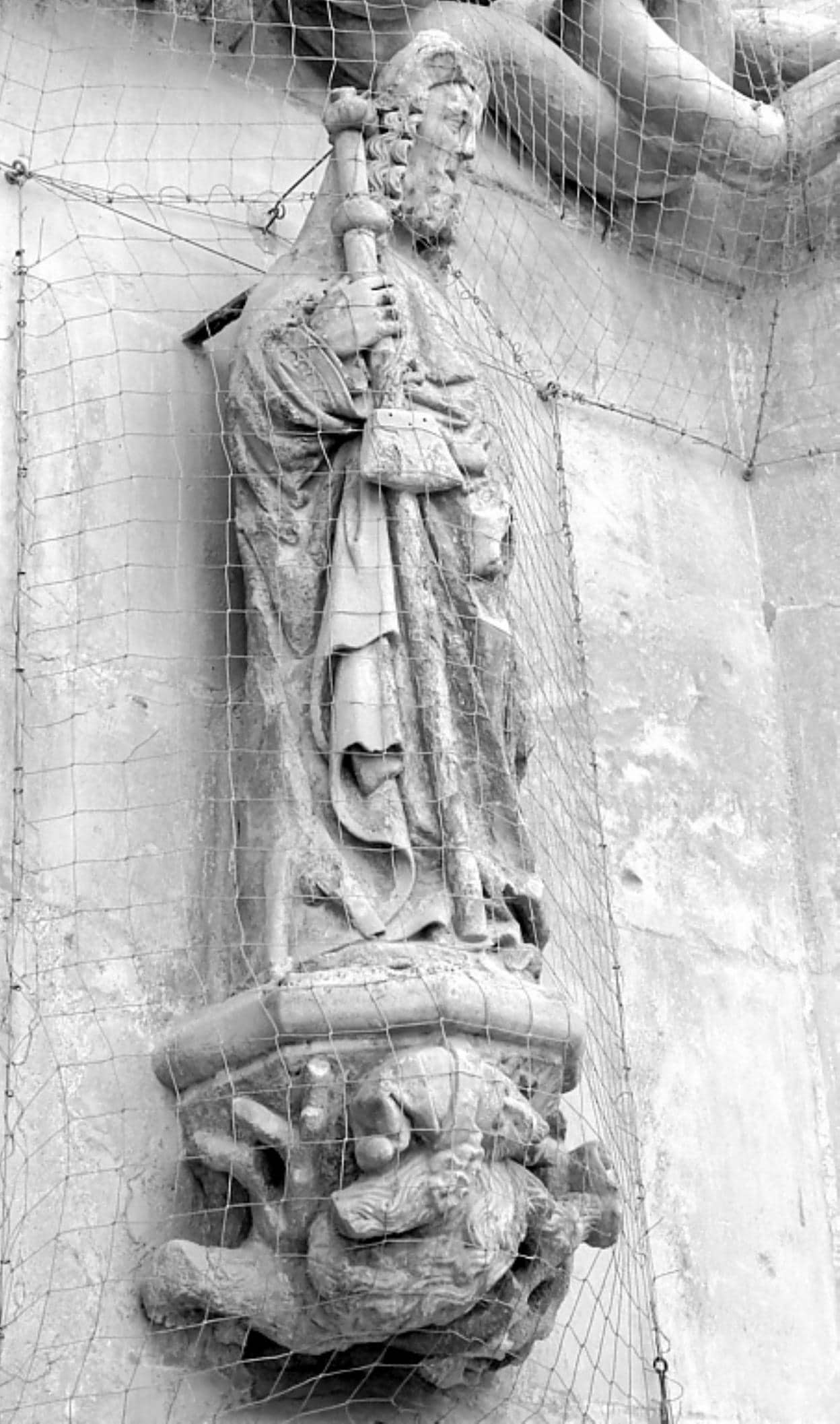 La supuesta escultura que representa al obispo fuera de la capilla de los Vélez y sobre un demonio.