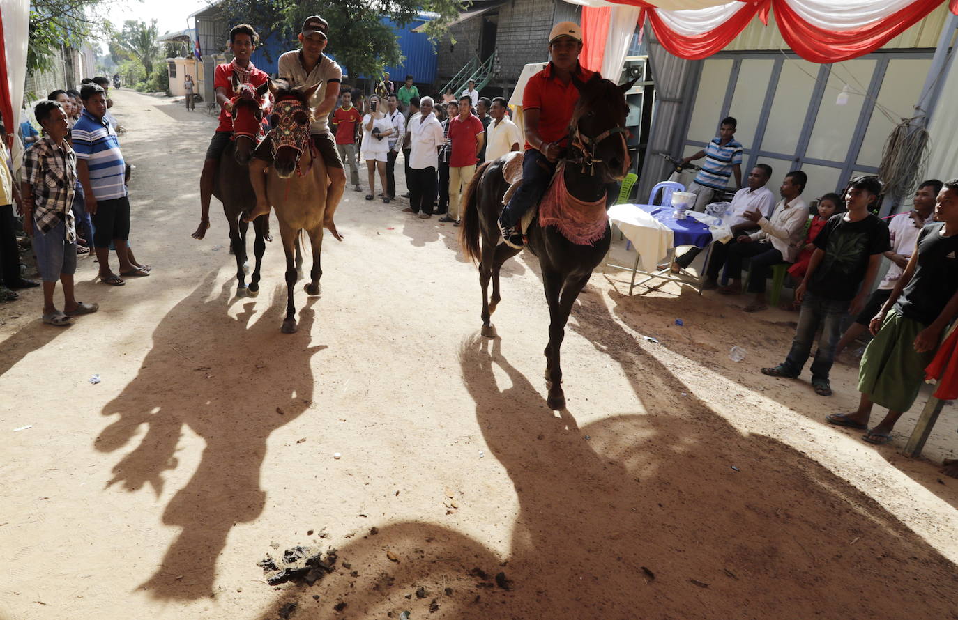 Varias personas participan en peleas y en carreras de búfalos y caballos organizadas con motivo de la culminación de la festividad de «Pchum Ben» o día de los ancestros, en la población de Sithor, Camboya.