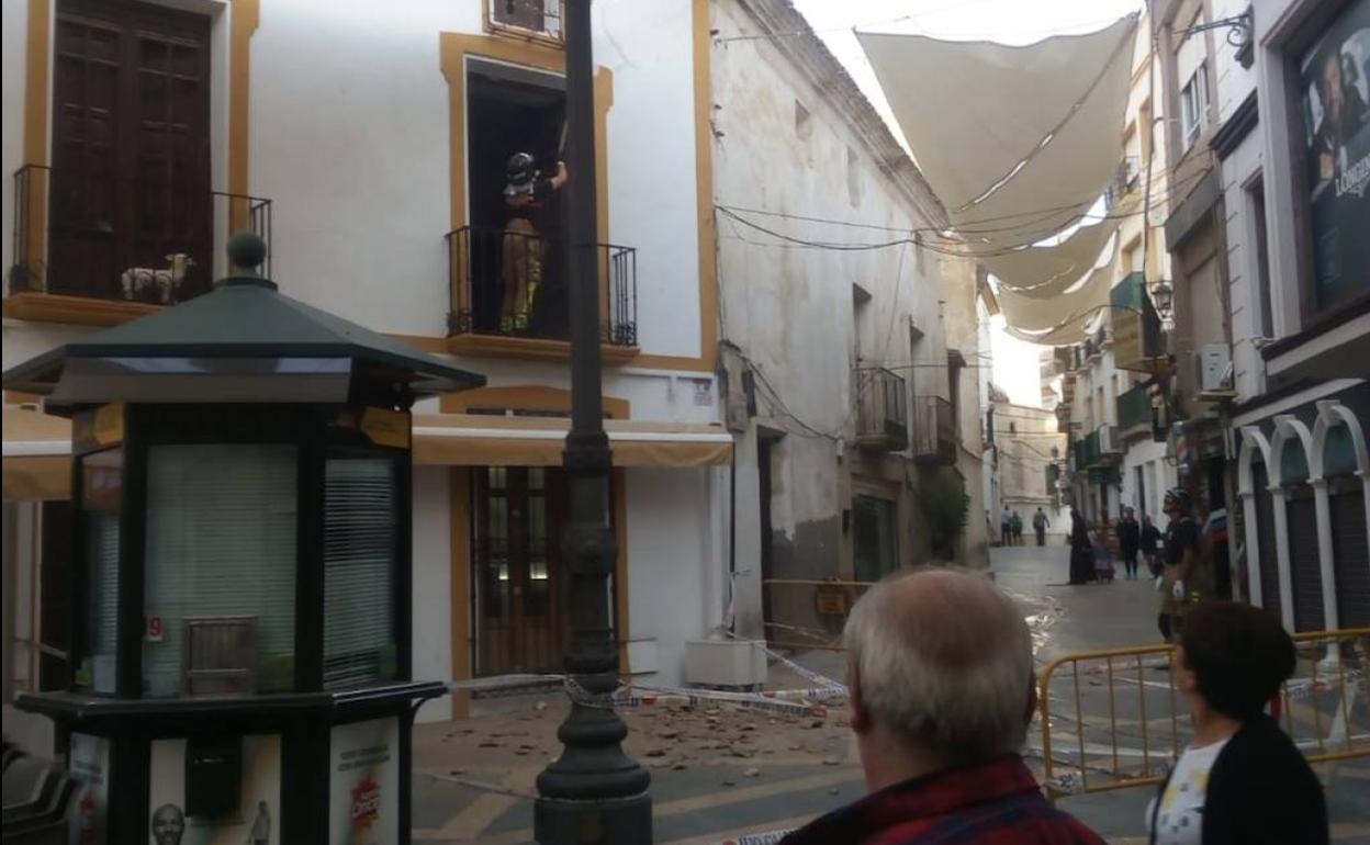 La calle Corredera, en el centro de Lorca, acordonada por la caída de una cornisa.