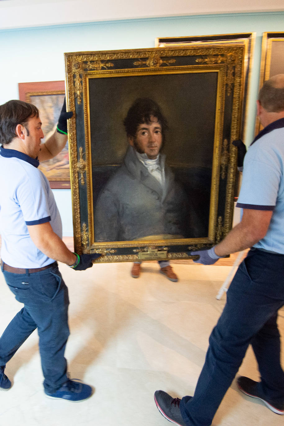 Dos técnicos cuelgan el retrato de Isidoro Máiquez, esta mañana en el Mubam.