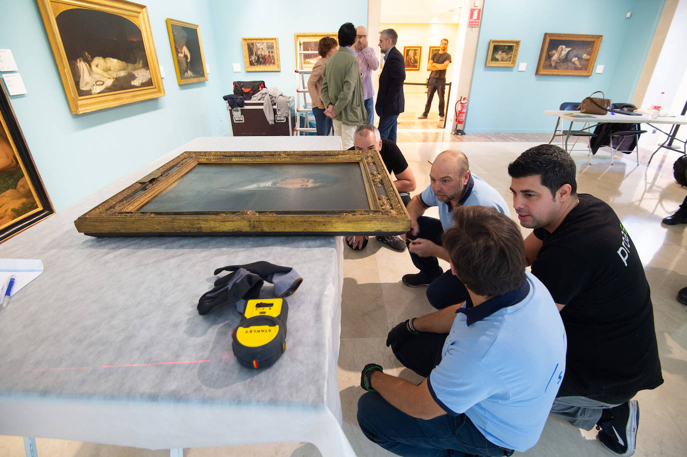 Dos técnicos cuelgan el retrato de Isidoro Máiquez, esta mañana en el Mubam.