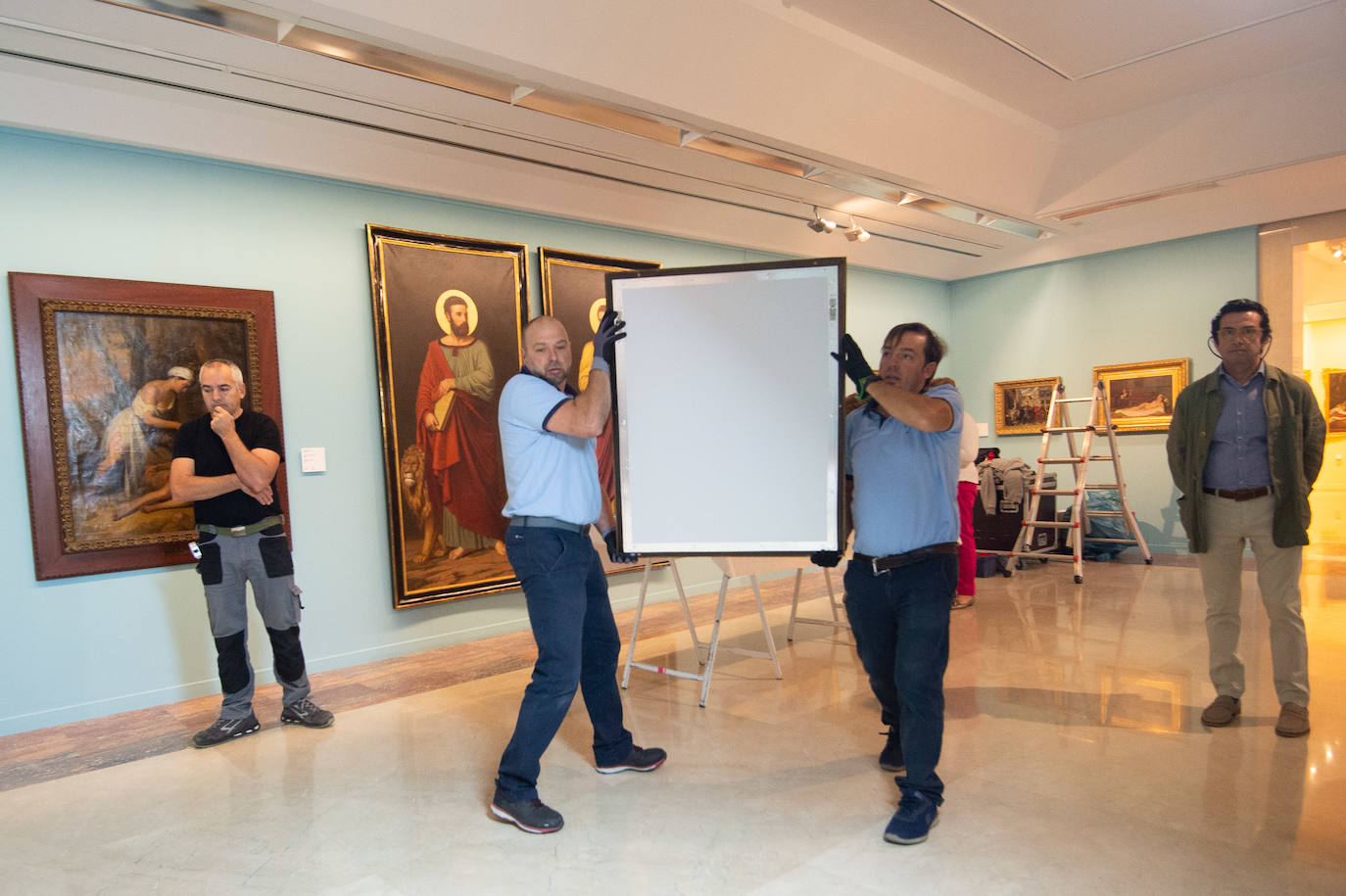 Dos técnicos cuelgan el retrato de Isidoro Máiquez, esta mañana en el Mubam.