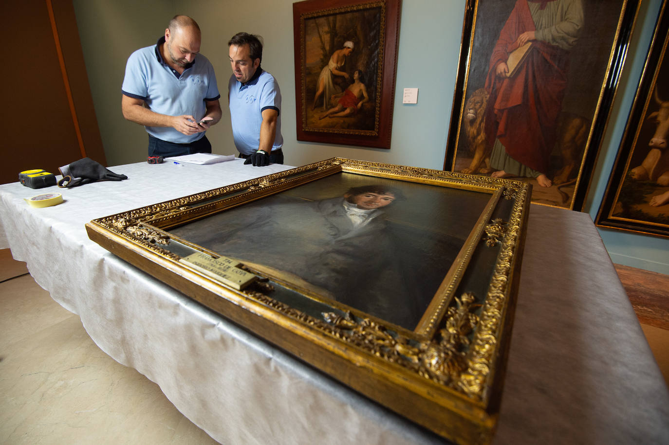 Dos técnicos cuelgan el retrato de Isidoro Máiquez, esta mañana en el Mubam.