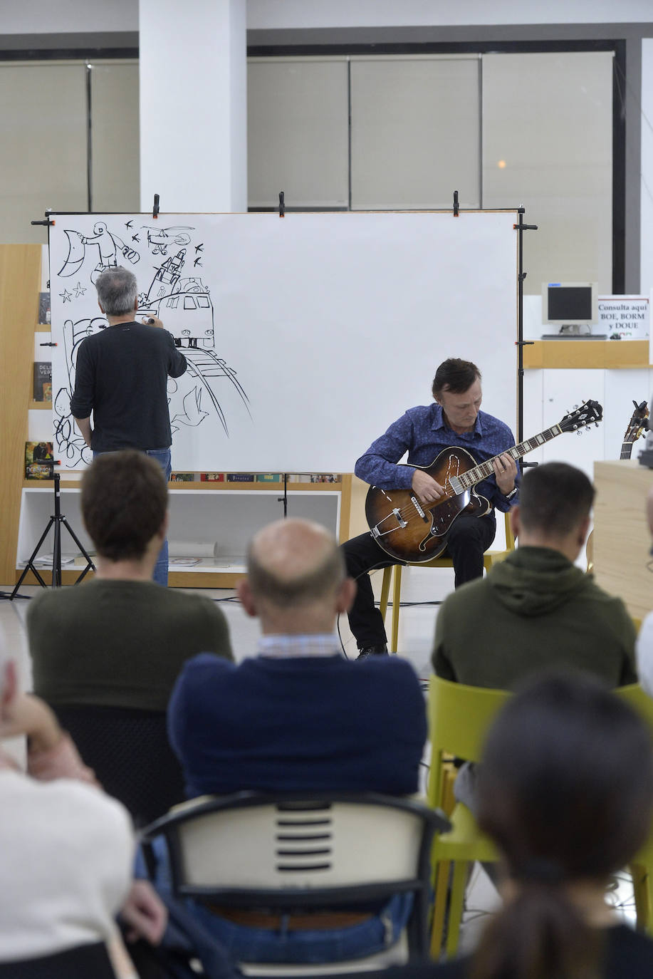 Con motivo del Día de las Bibliotecas, la Biblioteca Regional fue ayer escenario de una sesión de 'CómicJazz': espectáculo visual y sonoro en el que participaron el guitarrista Maxi Garcés y el dibujante Juan Álvarez. Garcés, que proviene del mundo del rock, interpretó piezas de jazz, pop-rock y clásicas y Álvarez dibujó en un panel de dos metros, de tal forma que los trazos aparecían al son de la música.