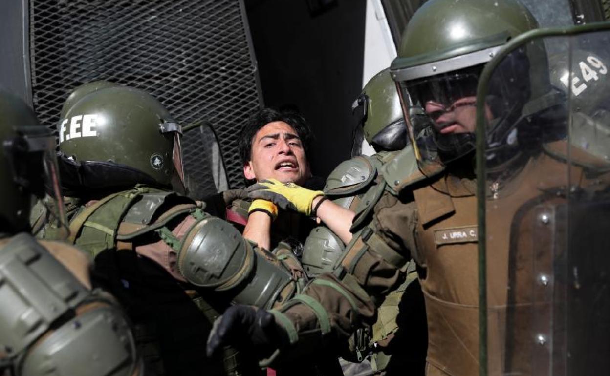 La Policía deteniene a uno de los manifestantes.