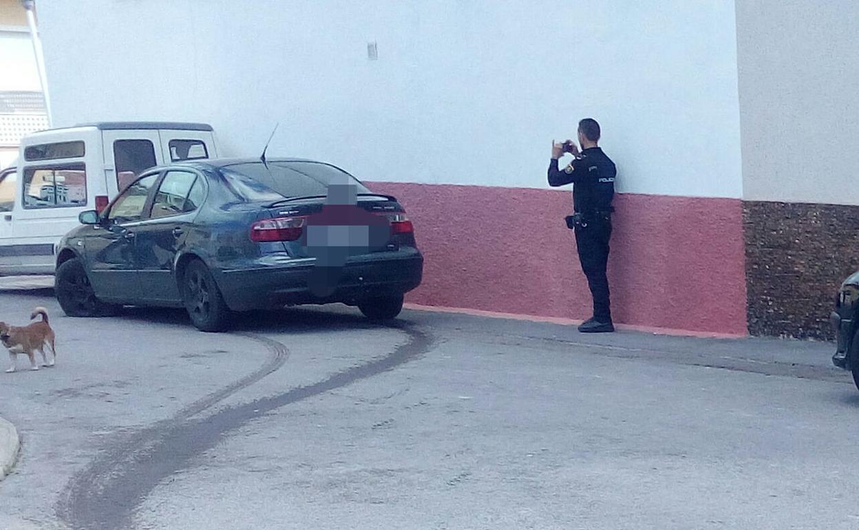 Un agente fotografiando el vehículo implicado en la fuga.