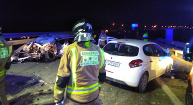 Un bombero observa los vehículos destrozados que se vieron implicados en el accidente múltiple. :