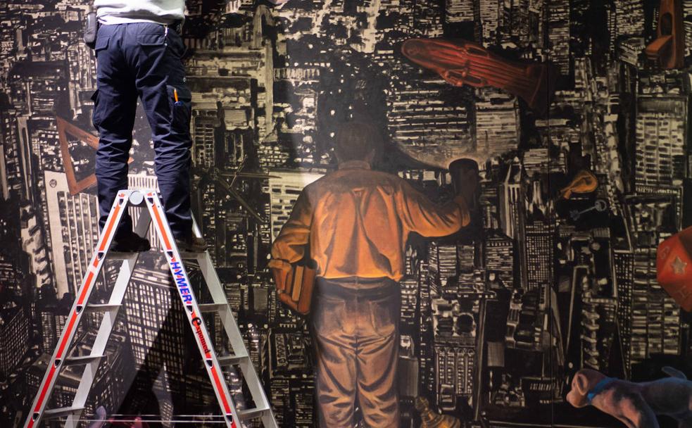 Un operario monta la pintura 'El Melancólico', de Curro González, en el Palacio Almudí, el pasado jueves.