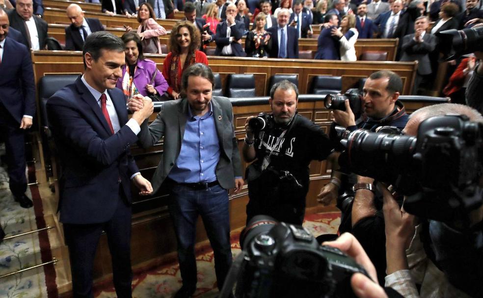 FOTO: Pablo Iglesias (d), felicita a Pedro Sánchez frente a las cámaras. | VÍDEO: El recién elegido presidente recibe el aplauso de las bancadas del PSOE y Podemos tras el anuncio de la votación