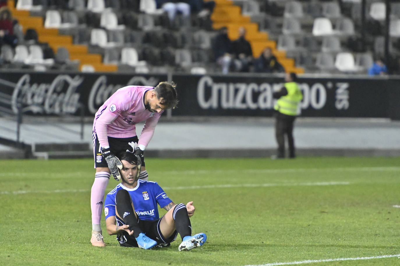 Marc Martínez. portero del conjunto albinegro, ayuda a levantarse a Álex Martín, durante el partido frente al Badajoz, este miércoles.