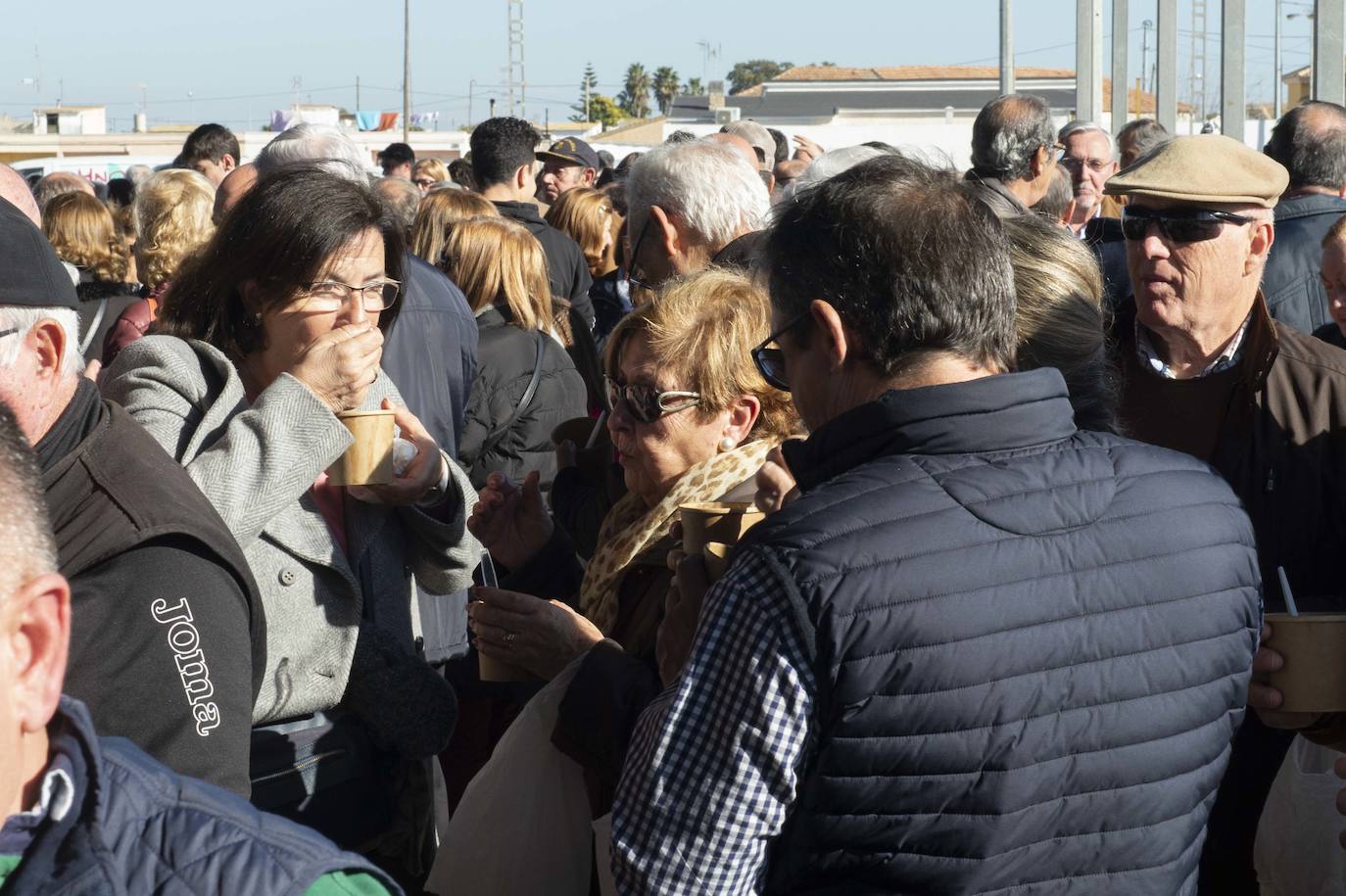 Decenas de personas se agolpan junto a las barras, donde amas de casa y peñistas sirven las típicas pelotas galileas