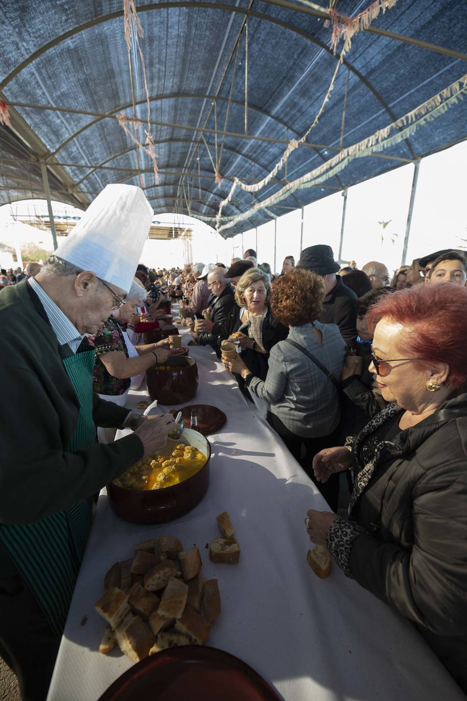 Decenas de personas se agolpan junto a las barras, donde amas de casa y peñistas sirven las típicas pelotas galileas