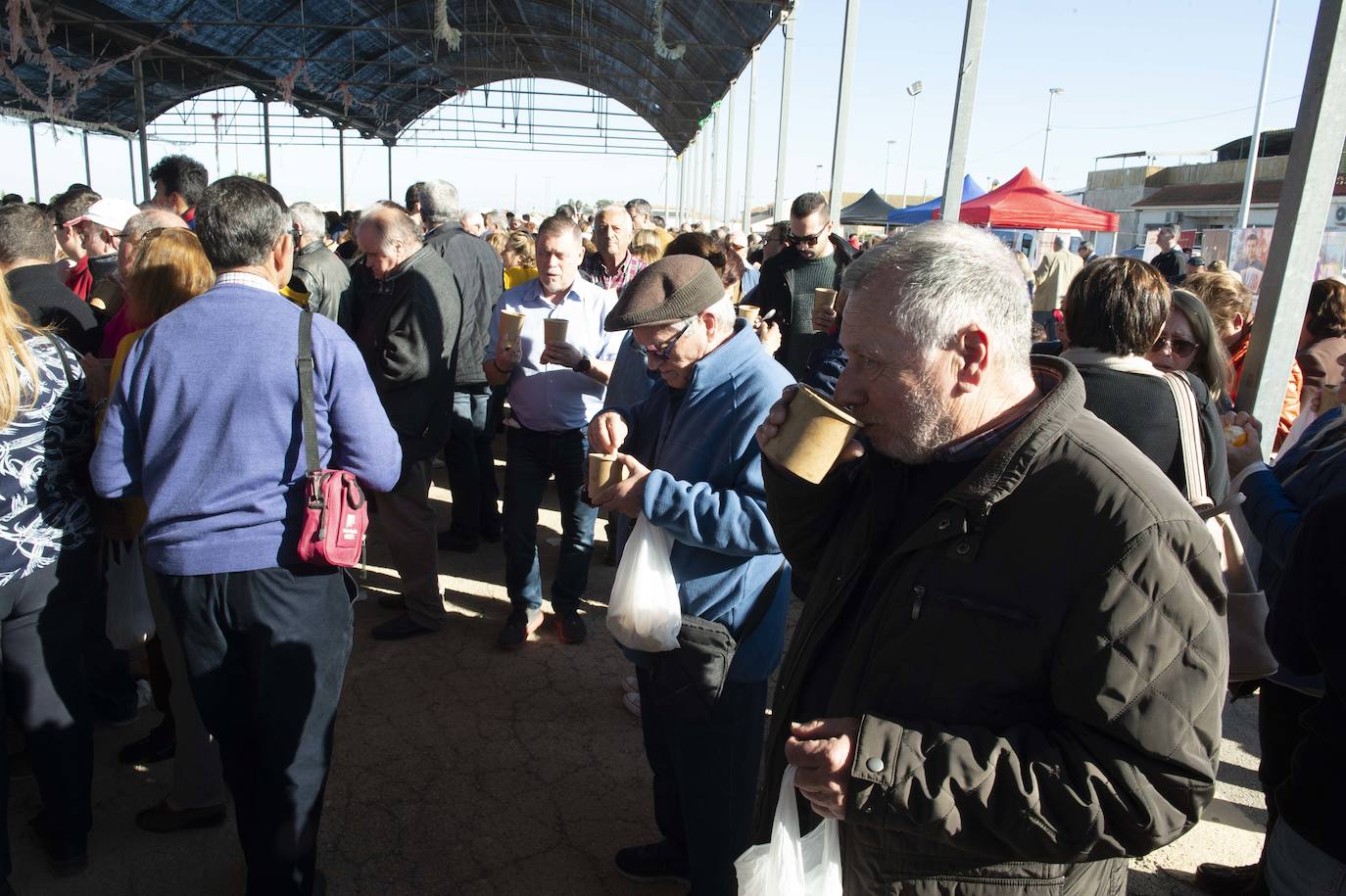 Decenas de personas se agolpan junto a las barras, donde amas de casa y peñistas sirven las típicas pelotas galileas