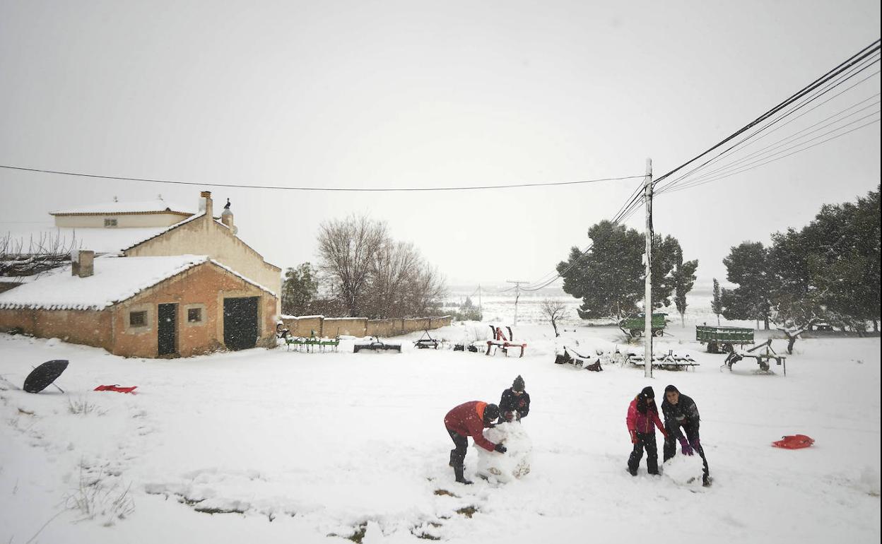 Jóvenes haciendo muñecos de nieve.