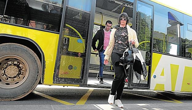 Dos usuarios de una línea interurbana de Lat, empresa dependiente de la Comunidad, bajan de un autobús en La Glorieta, ayer, frente al Ayuntamiento. 