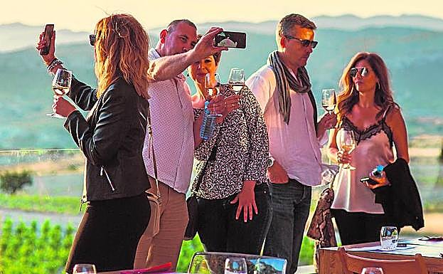 Los asistentes se fotografían, copa en mano, mientras observan el atardecer en las Bodegas Casa Rojo.