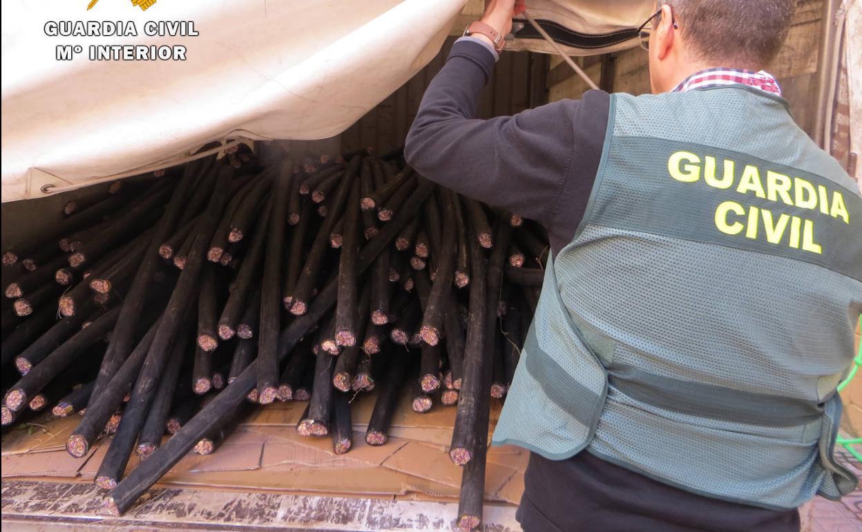 Un agente de la Guardia Civil junto al cable de cobre robado por los detenidos.