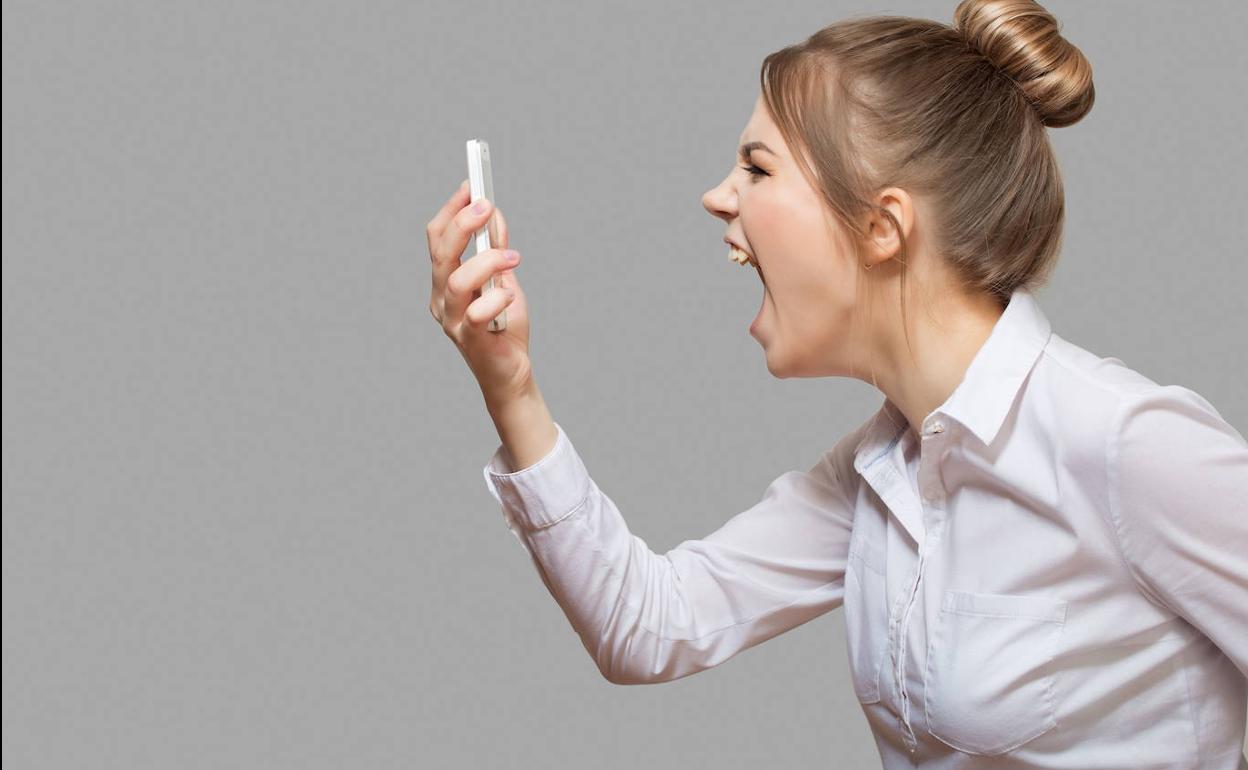 Una mujer grita a su teléfono móvil en una foto de archivo.