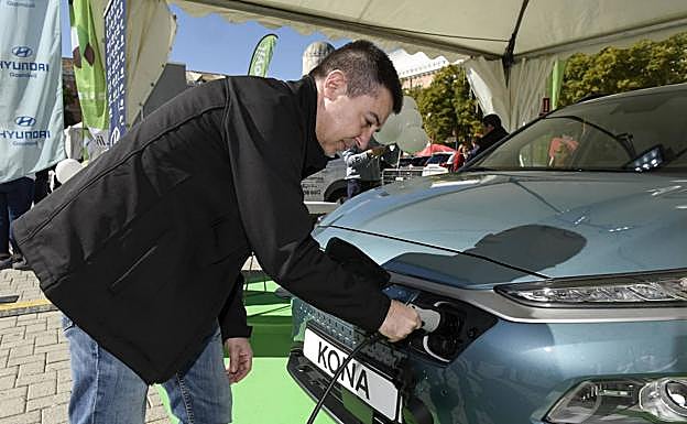 Un asistente prueba un cargador de un coche eléctrico.