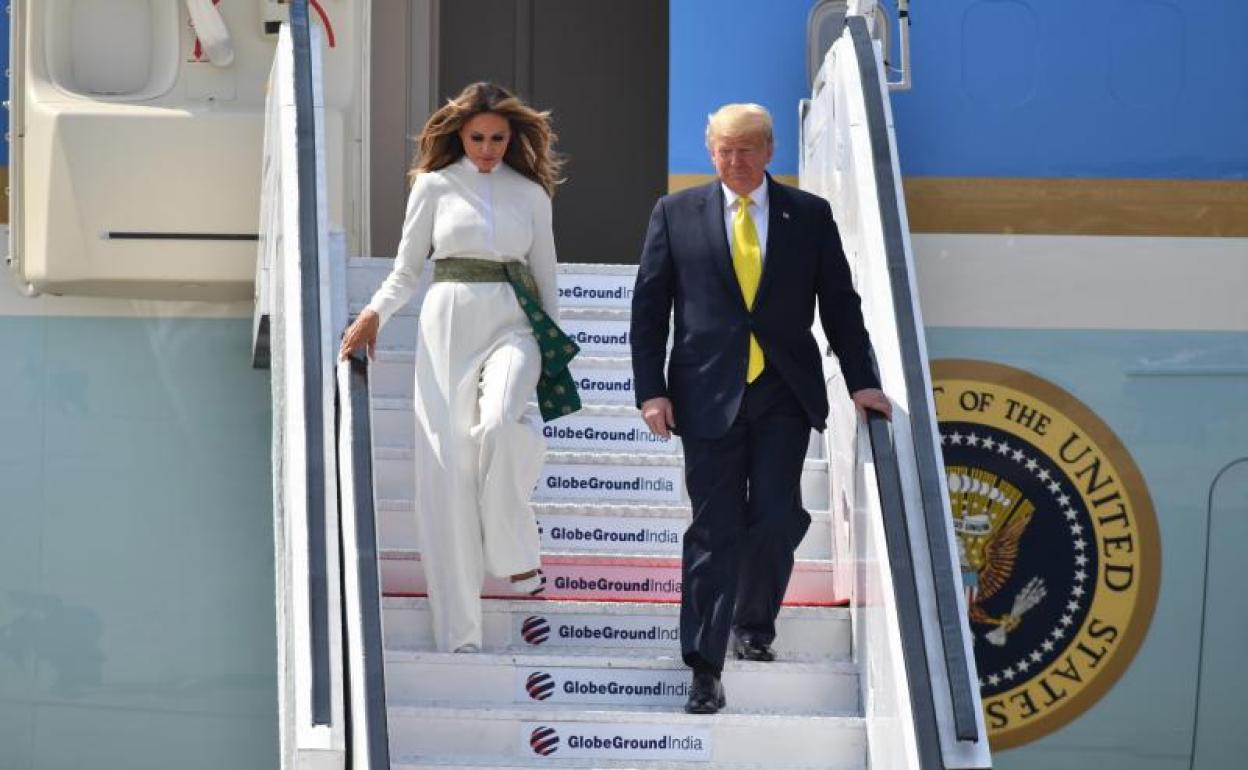 Trump y su esposa bajan del avión. 