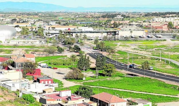 Panorámica de los terrenos del Plan Rambla, con las obras del vial en primer término y el centro comercial Eroski al fondo. La imagen fue tomada ayer. 