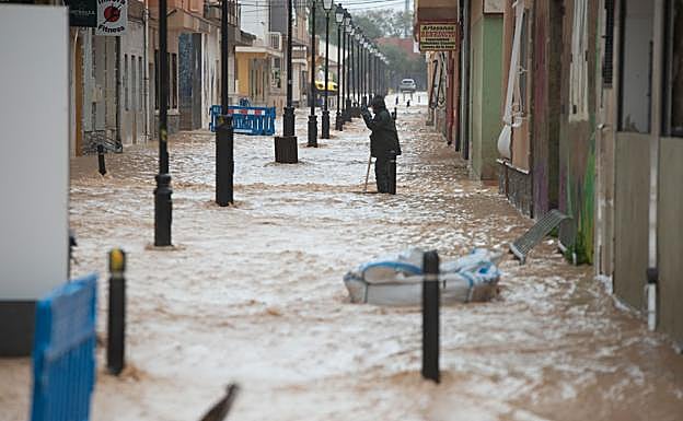 Un empleado municipal levanta tapas del alcantarillado. 