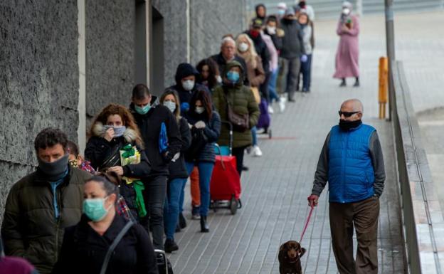 Varios clientes guardan cola para entrar en un supermercado de Badalona. 