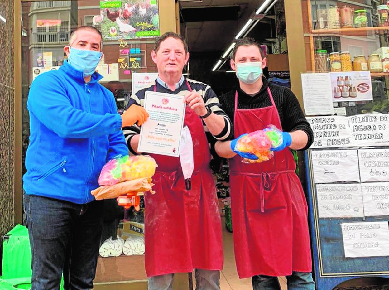 Entrega del cartel y de una bolsa con pitos a Diego Nicolás, de la tienda de Comestibles El Churra.
