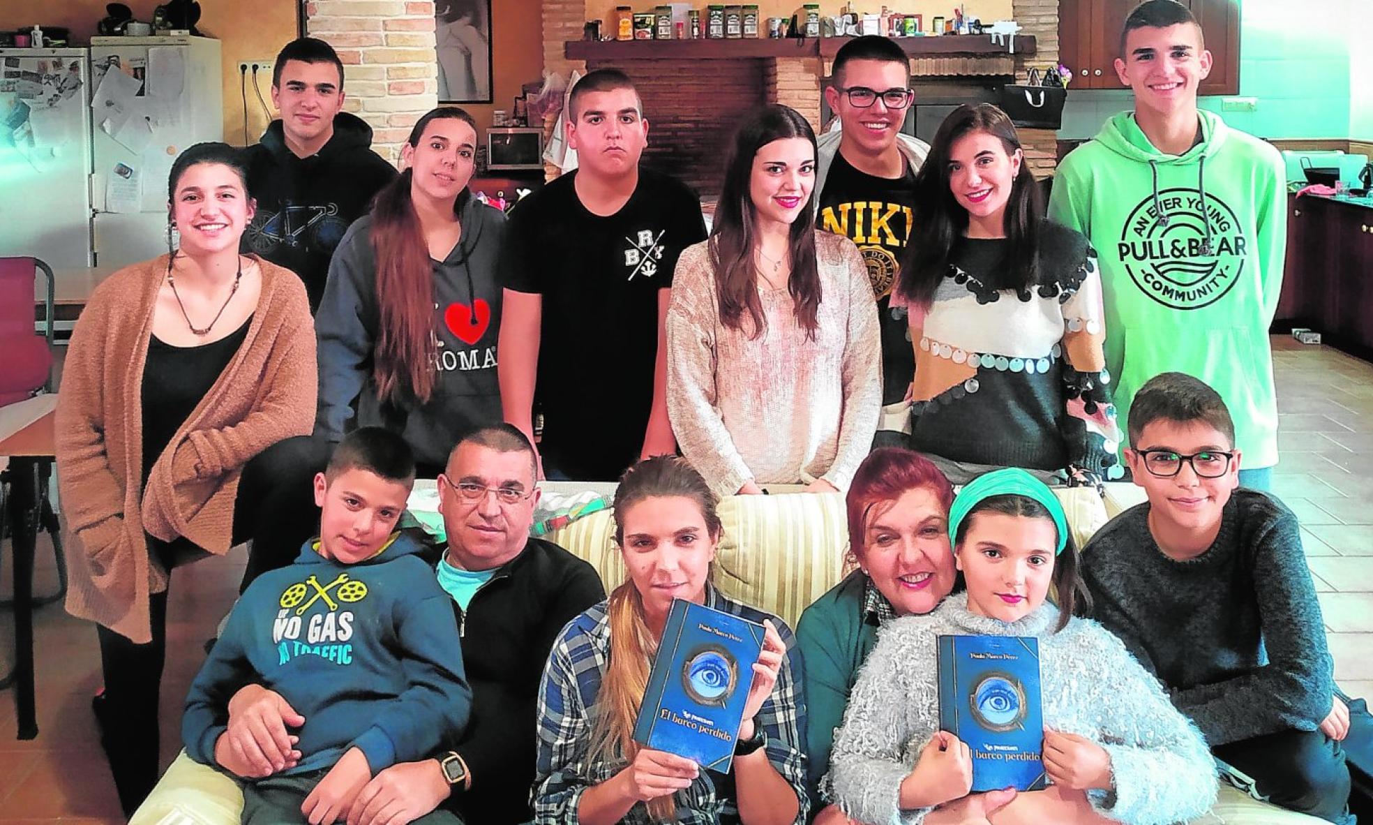 La yeclana Paula Marco, autora de 'El barco perdido', sentada entre sus padres y rodeada de sus once hermanos. 