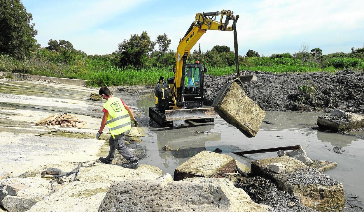 Una máquina retira los sillares de caliza de la presa de La Contraparada, ayer. 