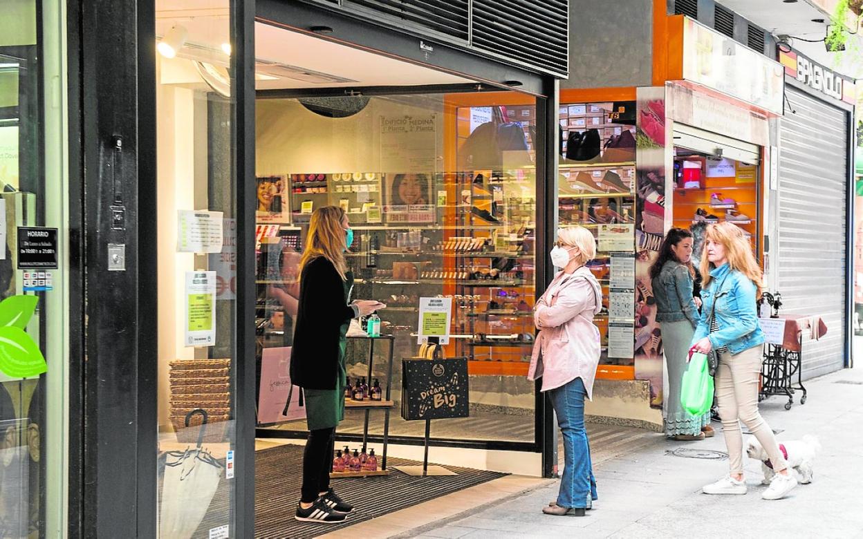 Varias personas, ayer, a las puertas de una tienda de cosméticos en Murcia. 