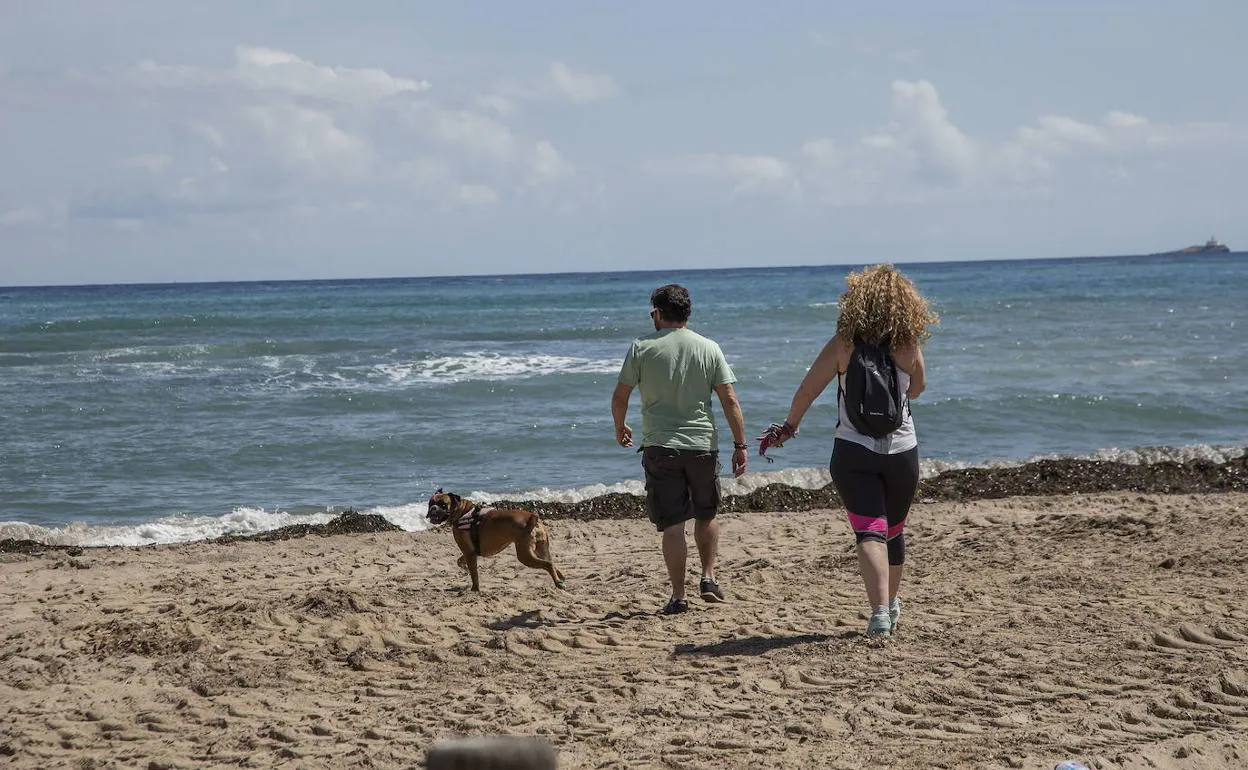 Una pareja pasea por una playa de La Manga, que podría reabrir al baño en la Fase 2. 