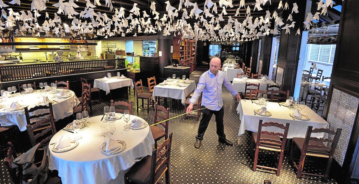 El dueño del restaurante La Pequeña, en Murcia, ayer, mide la distancia entre las mesas. 